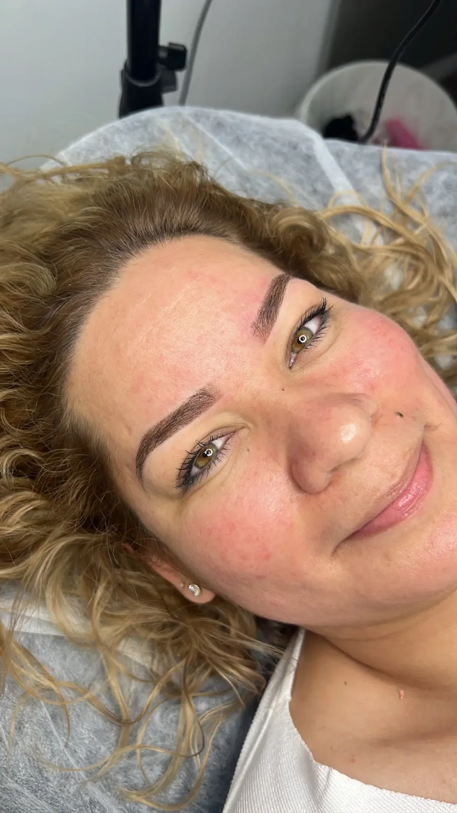 clienta sonriente tumbada (selfie), cejas